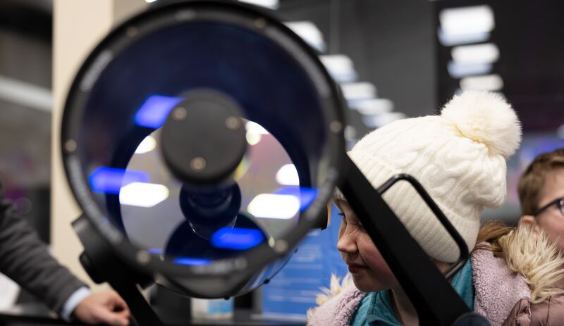 Child looking through telescope