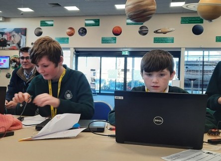 a pair of students are working on laptops during the Space Explorers event
